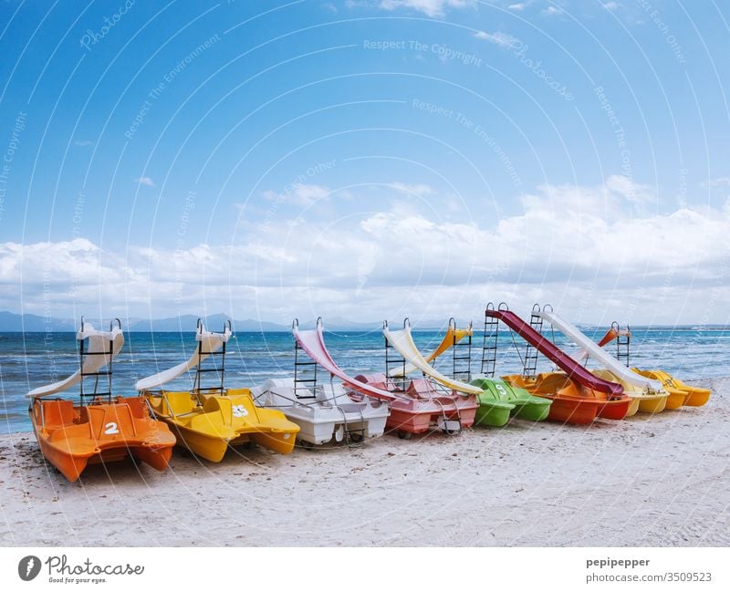 bunte Tretboote am Strand von Mallorca liegend Farbfoto Außenaufnahme mehrfarbig rot Tag orange grün gelb Menschenleer blau bunt gemischt Wasser Urlaub