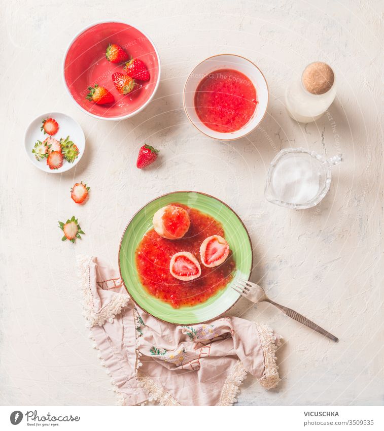 Schmackhafte gekochte Hüttenknödel, gefüllt mit frischen Erdbeeren. Sommersüßes Essen. Frühstück geschmackvoll Cottage Knödel erdbeeren Beeren Saucen grün