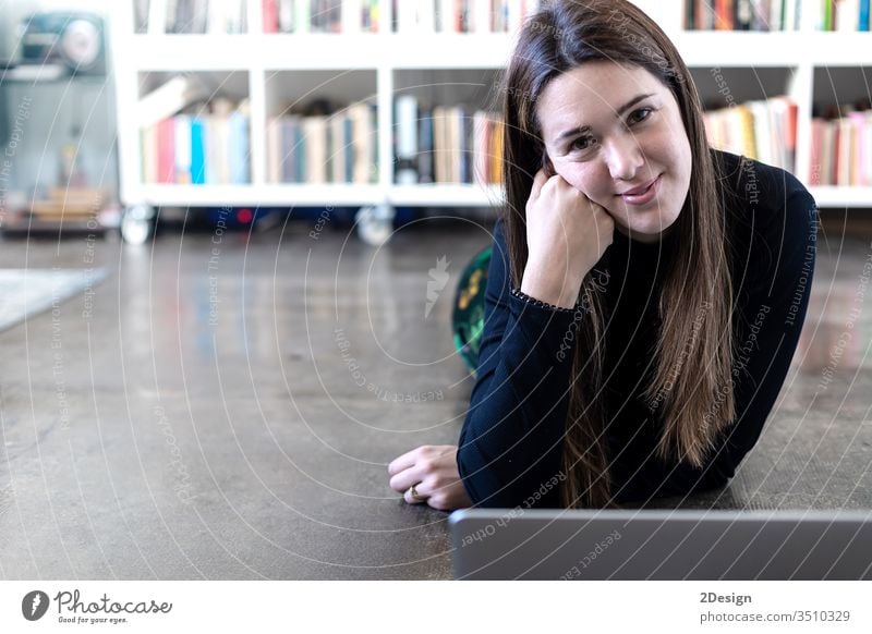 Junge, hübsche Unternehmerin, die einen Laptop benutzt, während sie zu Hause auf dem Boden sitzt. jung Frau 1 Computer Stock heimwärts Menschen Person