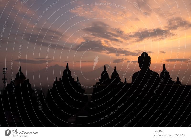 Besuch des Borobudur-Tempels auf Java (Indonesien) für einen erstaunlich farbenfrohen Sonnenaufgang. Sonnenuntergang Himmel Silhouette Skyline Großstadt orange