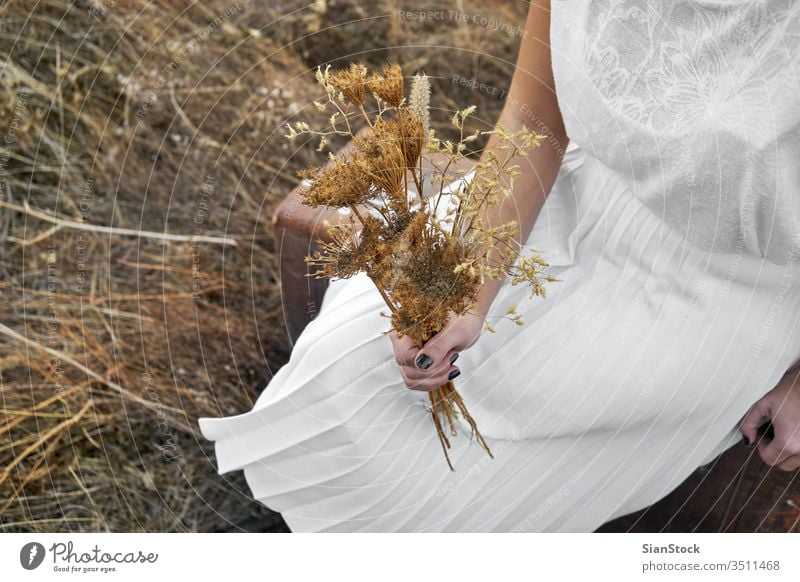 Frau mit weißem Kleid hält Blumenstrauß mit Trockenblumen Sonne Winter braun im Freien Menschen Glück Porträt reisen Lifestyle trocknen Beteiligung Hände Dame