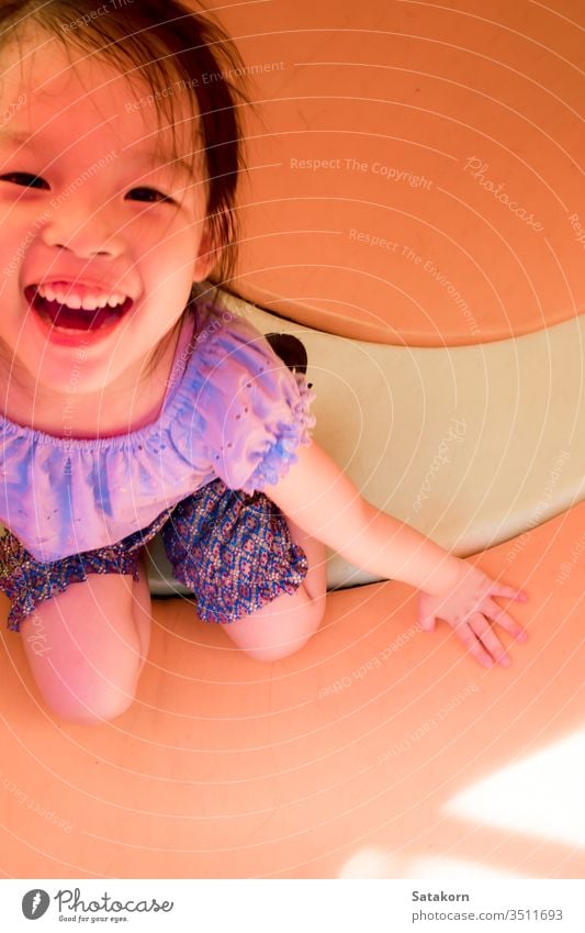 Kleines asiatisches Mädchen spielt gerne auf dem Spielplatz im Freien wenig Lächeln Kinder Glück Spaß genießen niedlich Spielen Aktivität Kindheit spielerisch