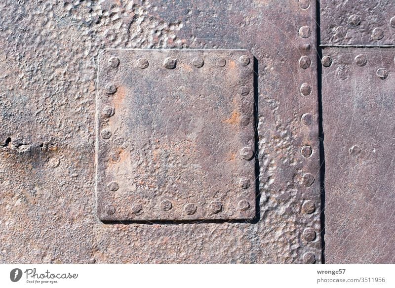 Nahaufnahme eines genieteten  stählernes Flicken auf einer stark korrodierten Schiffswand Genietet nieten Niet Stahl Bootswand Metall alt Nieten Farbfoto