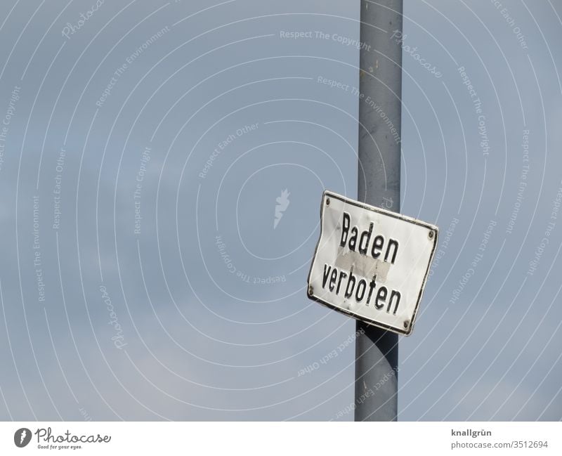 Verbeultes „Baden verboten“ Schild an einem Mast vor bedecktem Himmel Schilder & Markierungen verbeult Verbote bedeckter Himmel Buchstaben Wort Satz Typographie