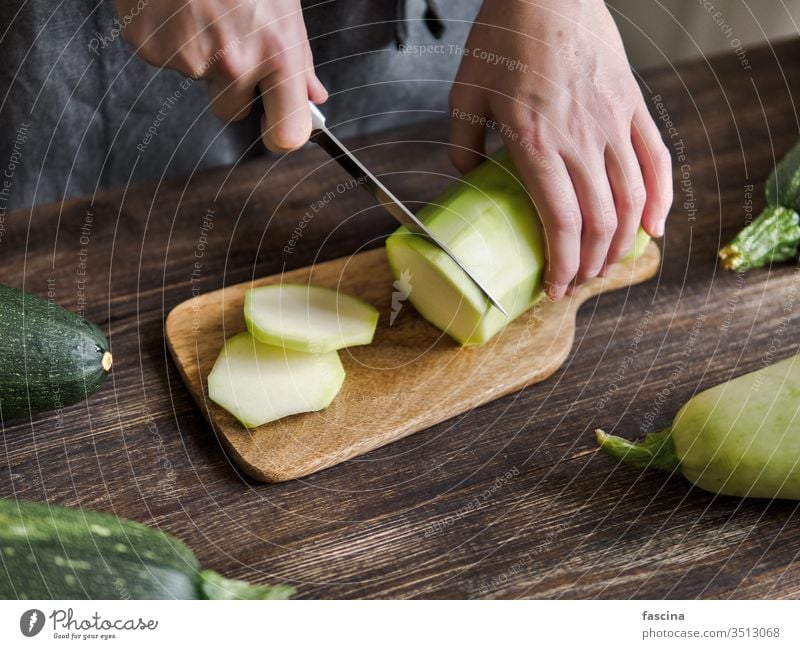 Zucchini-Erntekonzept. Ernten aufgeschnitten Frau Hand Messer frisch organisch Gemüse grün Bestandteil Lebensmittel Pflanze roh Sommer Vegetarier Bauernhof