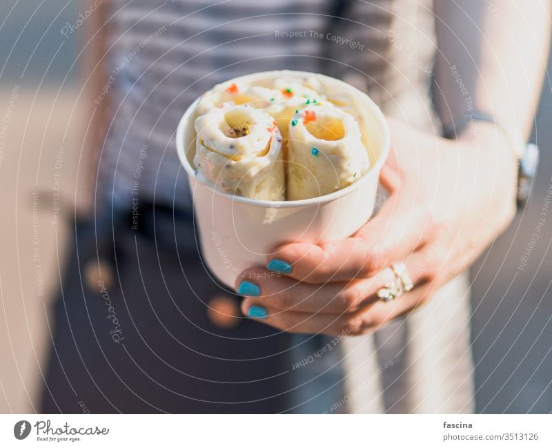 In der Hand gehaltenes gerolltes Eis in Tütenbecher rollen Eiscreme eisbedeckt Speiseeis Sahne Tasse Zapfen Frau gebacken Frucht braten Kopie Raum Textfreiraum