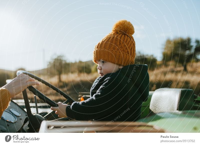 Kind auf dem Lenkrad Kindheit fahren Verkehr Farbfoto Mensch im Freien Außenaufnahme 1-3 Jahre Kindheitserinnerung Kleinkind Spielen Fröhlichkeit mehrfarbig Tag