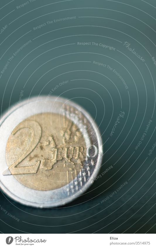 Nahaufnahme einer Zwei Euro Münze vor türkisem Hintergrund; Geld, Finanzen Makroaufnahme Eurostück hell Finazen Sparen Kapitalwirtschaft Geldmünzen Bargeld