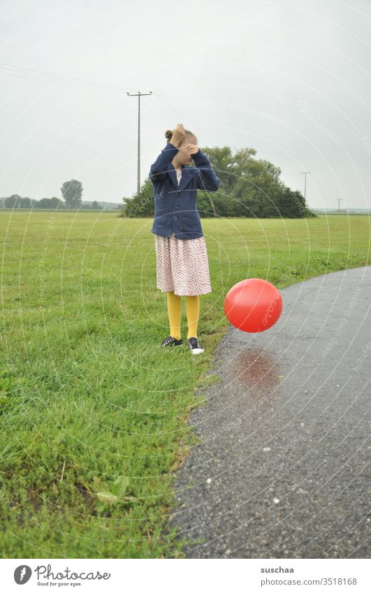 altmodisch gekleidetes mädchen spielt mit einem roten luftballon Mädchen Kind draußen Weg Wiese Gras Feld Luftballon roter Luftballon Ball rund spielen Umwelt