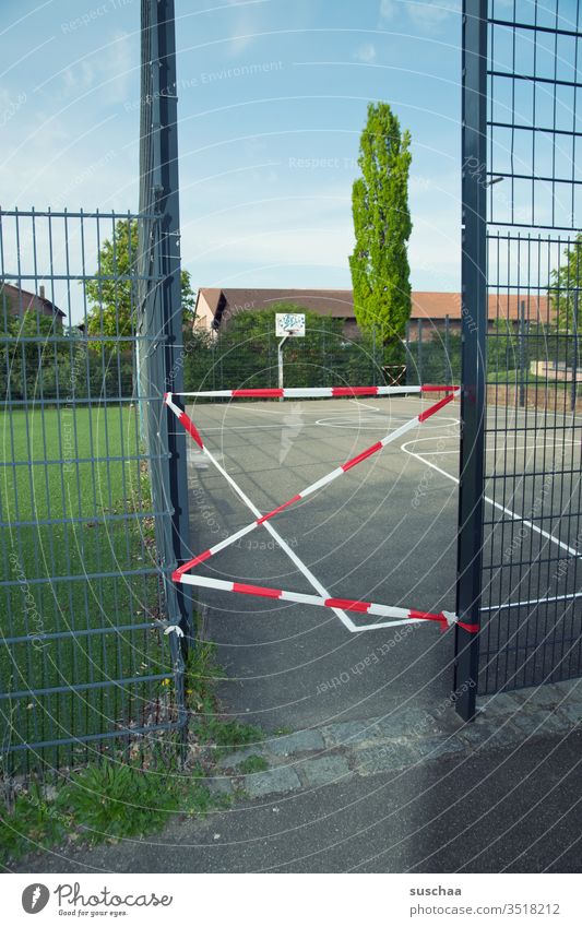 noch geschlossen? abgeriegelt Sportfeld Basketballplatz Basketballkorb leer Gitter Absperrband Rasen Linien Öffnung Durchgang versperrt stay home Lockdown