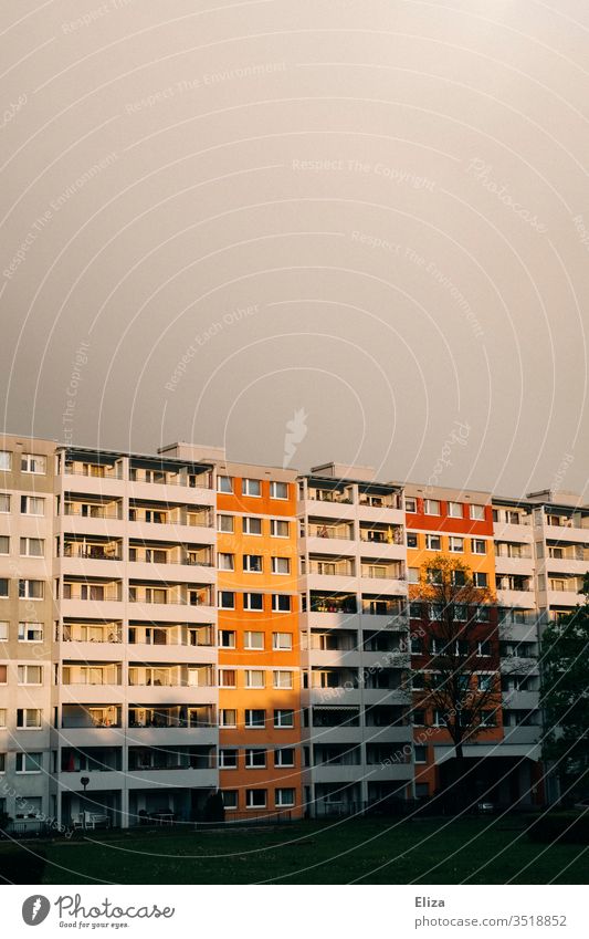 Wohnblock am Abend zwischen Regen und Sonnenschein Wohnhaus wohnen mehrfamilienhaus fassade mietshaus menschenleer hell erleuchtet freundlich hoffnungsvoll