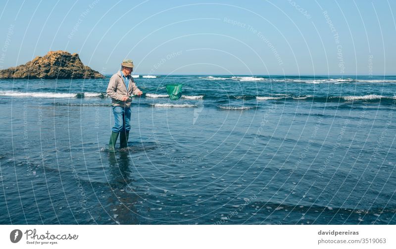 Freiwillige Helferin, die den Müll aus dem Meer holt Senior Mann herausnehmend Ufer MEER Fischernetz Umwelt Natur Sauberkeit Kunststoff Verschmutzung Abfall