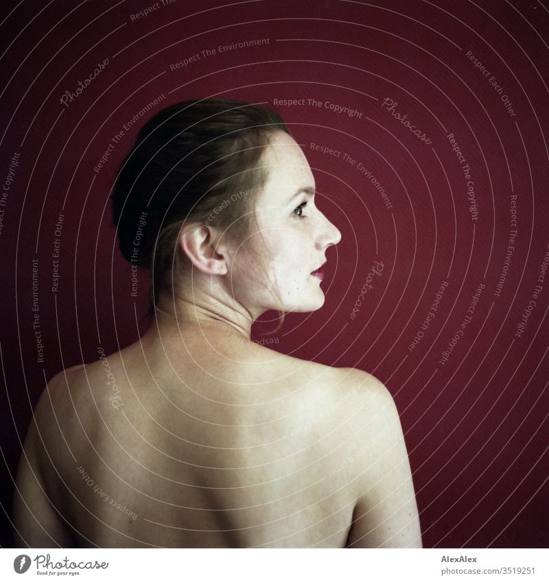 Analoges Portrait in Hinteransicht einer jungen Frau vor einer roten Wand zart Schatten Licht gemäldeartig sportlich feminin Empathie Gefühle emotional Porträt