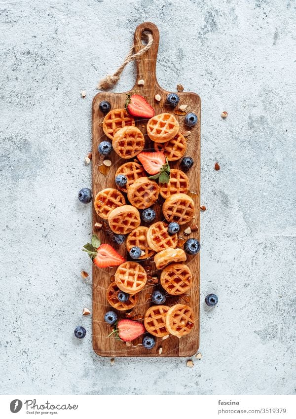 Köstliche belgische Waffeln mit Beeren, Kopierraum Belgier Belgische Waffeln Blaubeeren Belgien rund klein lecker Schneiden Holzplatte Dessert Erdbeeren