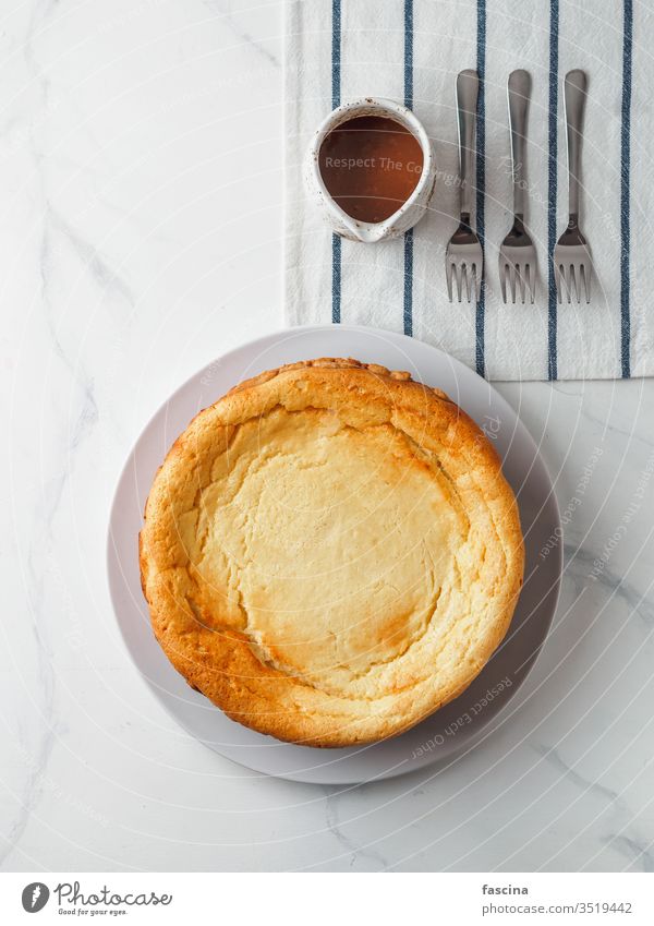 Klassischer Käsekuchen auf weißem Marmortisch. Ansicht von oben klassischer Käsekuchen Karamell Karamell-Backenkopf selbstgemacht Saucen Hintergrund frisch