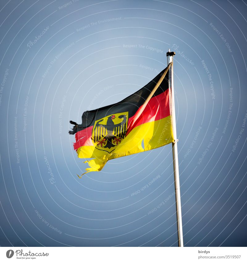 beschädigte Deutschlandfahne mit Bundesadler, Symbolbild für Instabilität und Zersetzung Deutschlandflagge Wind kaputt zerrissen Deutsche Flagge Menschenleer