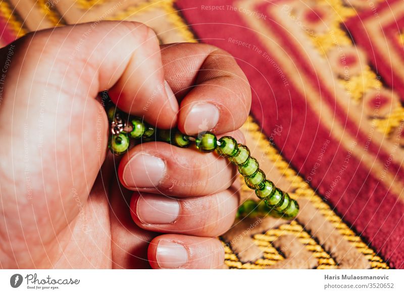 In der Hand haltender muslimischer Rosenkranz zum Mattengebet im Ramadan Kareem arabisch Kunst Hintergrund Buch Kultur Design dhikr dua Osten Glaube Fasten