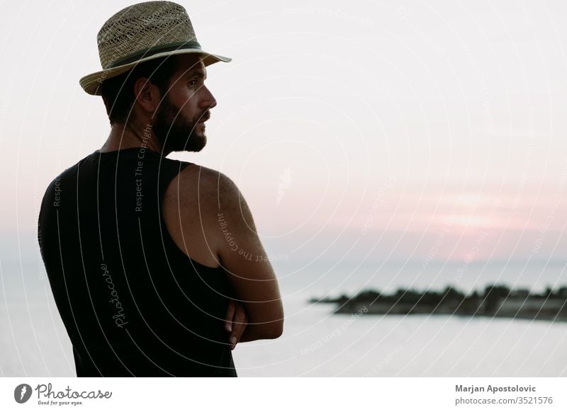 Junger Mann genießt Sonnenuntergang am Meer Erwachsener Abenteuer allein Strand Küste Morgendämmerung Abenddämmerung genießen Genuss Freiheit Typ gutaussehend