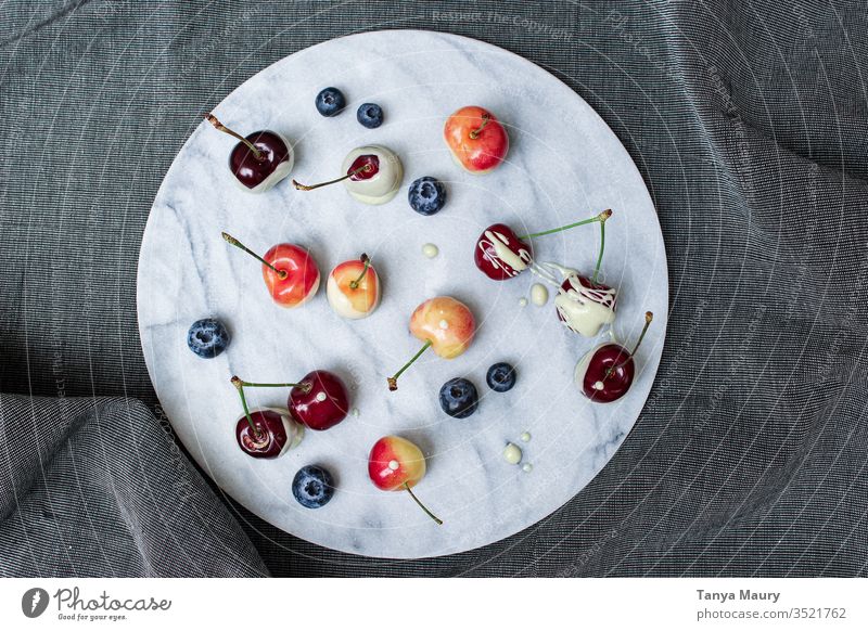 Orangen und rote Kirschen mit Beeren Frucht Sommer frisch lecker saftig Natur Ernte Orangenkirsche weiße Schokolade Blaubeeren organisch Lebensmittel grün