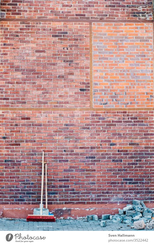 Besen und Schaufel stehen an Ziegelwand Tag Reinigen Außenaufnahme Wand Kehren Menschenleer Sauberkeit Farbfoto dreckig Besenstiel Mauer Detailaufnahme Bauwerk