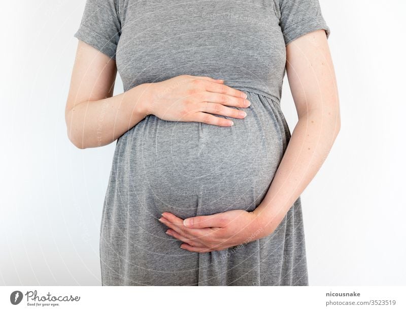 Schwangere Frau, die sich um ihr Baby kümmert und Liebe mit ihm teilt, indem sie ihren Bauch mit den Händen berührt Mama elterlich Umarmen Kind Streicheln