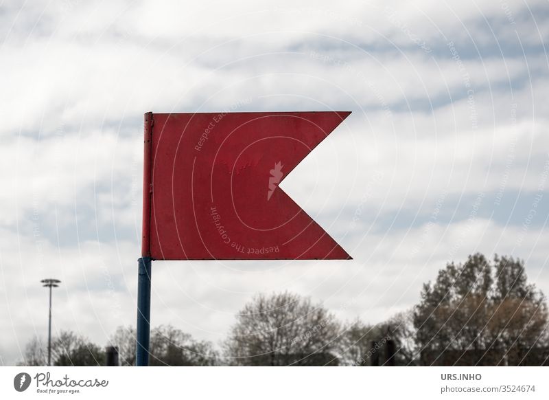 rotes Metallfähnchen vor Baumkronen Fahne Fähnchen bewölkt Himmel Tag weiße Wolken wehen Signal Achtung