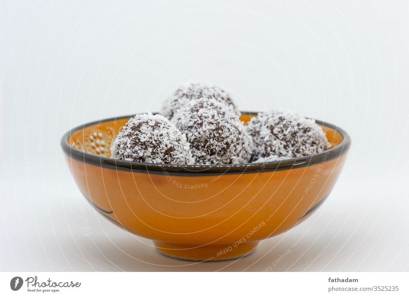 Kokosnusskugeln in einer orangefarbenen Kugel Hintergrund Ball Bälle Schalen & Schüsseln braun coco Kokoskugel Keks lecker Dessert Lebensmittel selbstgemacht