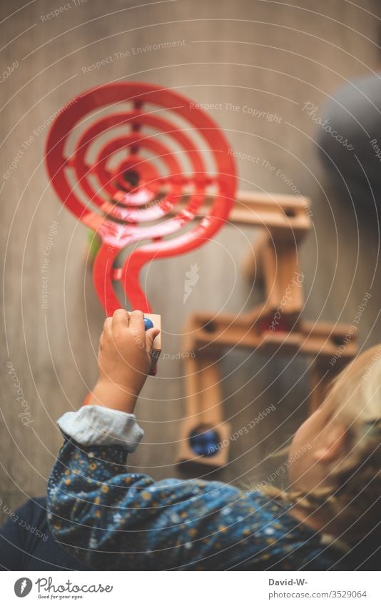 Mädchen Kind spielt mit Murmeln Holzspielzeug Kindheit niedlich Kleinkind Spielen Spielzeug Vogelperspektive Spaß haben Kindergarten Freude Kinderbetreuung