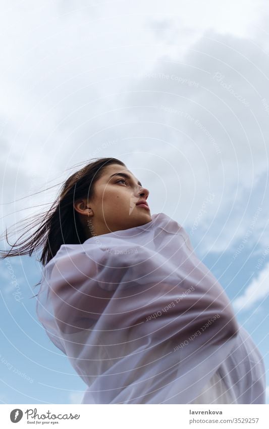 Junge erwachsene Frau hält ein Stück durchsichtiges Tuch im Freien Erwachsener schön Schönheit Stoff Vorhang Gewebe Mädchen Person Porträt Himmel Textil Wind