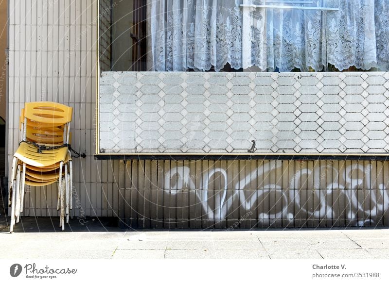 corona thoughts |Gelbe Stühle warten angekettet an einer Fünfziger-Jahre-Retro-Wand auf ihren Einsatz. Die coronavirus coronakrise Coronavirus SARS-CoV-2