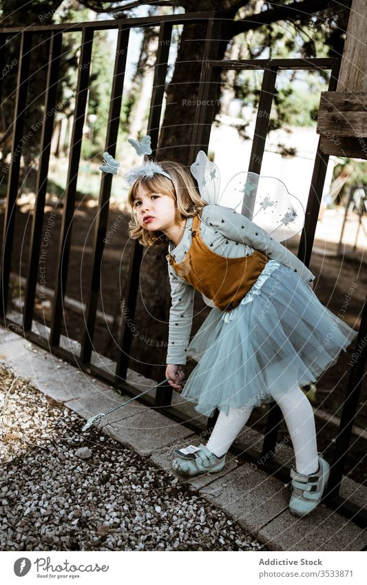 Kleine Fee sitzt im Hof Mädchen Tracht Bank sitzen schäbig niedlich wenig spielen bezaubernd Kind Park Kindheit Garten verwittert Maskerade sich[Akk] entspannen