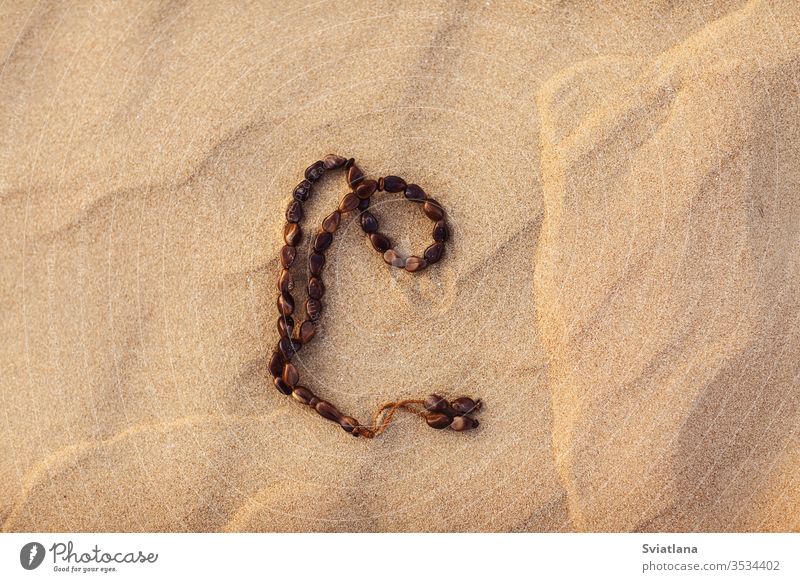 Rosenkranz auf dem Sand in der Wüste. Ramadan Kareem Daten arabisch Kultur Kaffee Lebensmittel Wasserkessel Tradition wüst Türkisch Sonne pho trinken uae Hunger