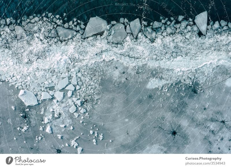 Gletscherlagune mit Eisbergen von oben. Luftaufnahme. Risse im Eis aus der Drohnenansicht. Konzept der Hintergrundtextur. blau Ansicht Wasser weiß Natur