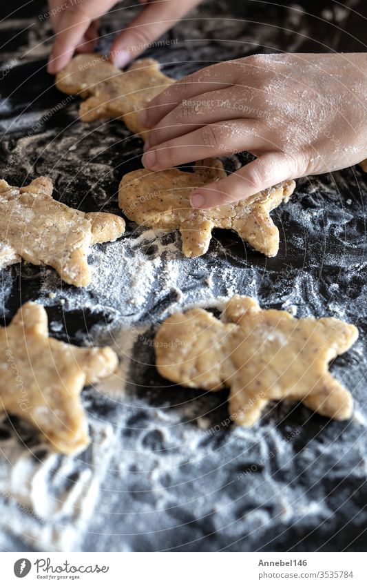 Person backt Lebkuchen Mann Kekse, Person reicht Teig mit Blume in gemütlicher Küche Weihnachten Teigwaren Mehl selbstgemacht traditionell Dessert Brot Feiertag