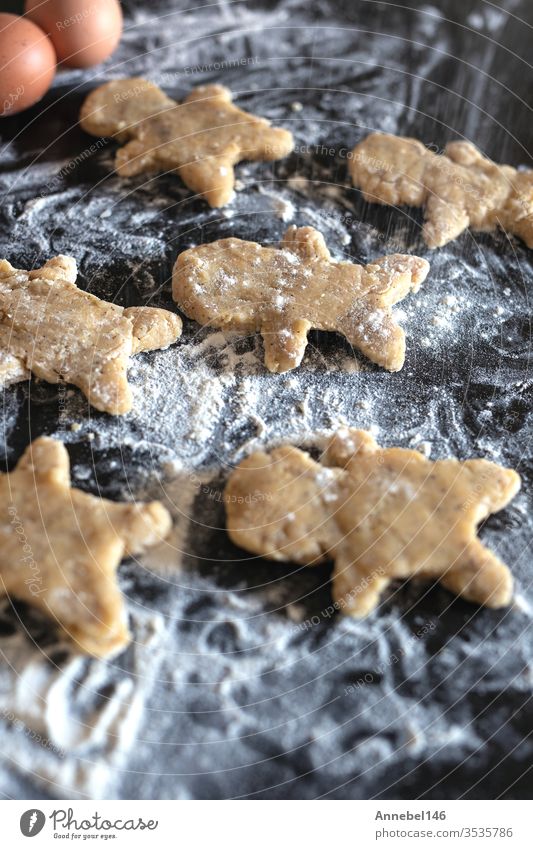 Person backt Lebkuchen Mann Kekse, Person reicht Teig mit Blume in gemütlicher Küche Weihnachten Teigwaren Mehl selbstgemacht traditionell Dessert Brot Feiertag