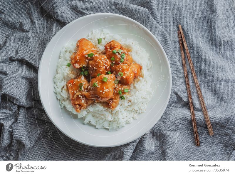 Köstliches Hühnerfleisch mit süßsaurer Orangensauce und Jasminreis nach chinesischer Art, Draufsicht. Kochen Schalen & Schüsseln Tisch Peperoni Hähnchen orange