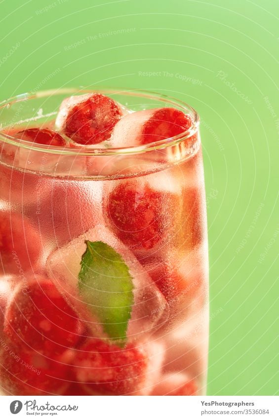 Glas Wasser mit gefrorenen Himbeeren. Kaltes Getränk. Beeren kalt cool Kristalle Entzug Diät trinken Flüssigkeiten frieren frisch Frost gefrorene Früchte Eis