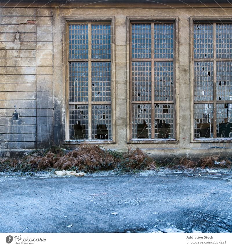 Altes Industriegebäude mit zerbrochenen Fenstern Gebäude Verlassen Wand industriell gebrochen schäbig verwittert Ruine Stein Raster Glas niemand