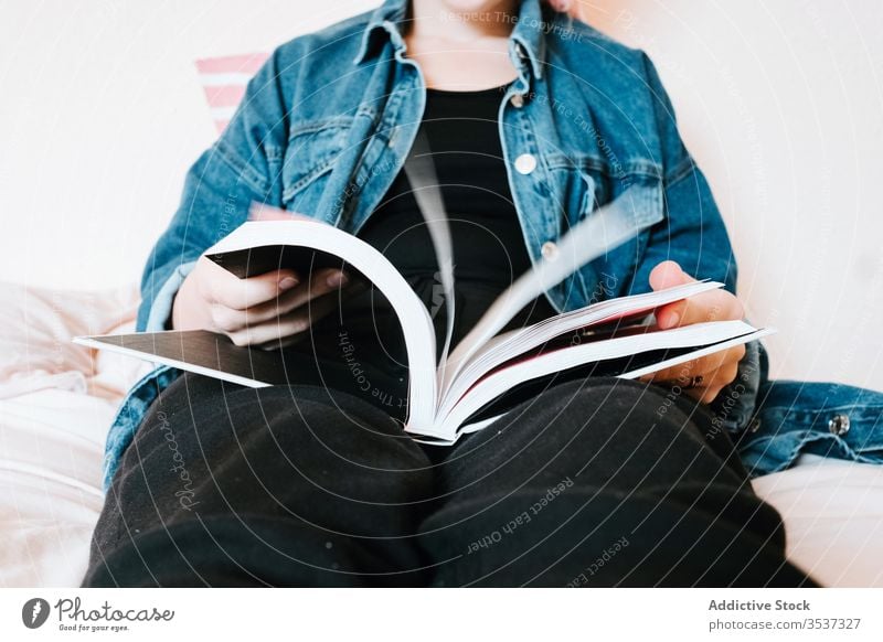 Gelangweilte Studentin blättert Lehrbuch in hellem, modernem Schlafzimmer Frau umdrehen Buch heimwärts Bett Schüler Kälte Leseratte gelangweilt