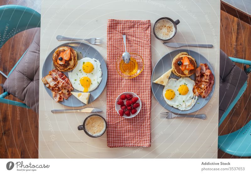 Leckere Spiegeleier mit Speck und Käse zum Frühstück Teller Ei Muffins erdbeeren schwarze Beeren Liebling Lebensmittel dienen Mahlzeit gebraten Pfannkuchen