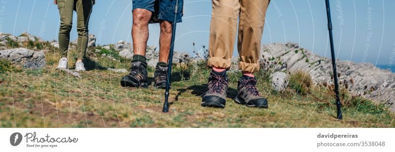 Drei Personen, die Trekking im Freien praktizieren unkenntlich Menschengruppe Wanderer Bergstiefel Beine kleiner Abschnitt Wanderung Trekkingstöcke Transparente