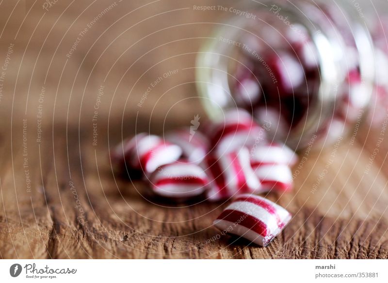 gestreiftes Süßes Lebensmittel Ernährung Essen rot weiß Bonbon Schwache Tiefenschärfe Glas Holztisch lecker Kalorie Süßwaren lutschen Streifen geschmackvoll