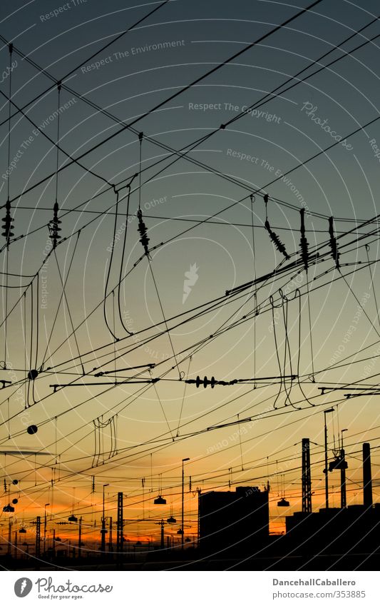 Stadtansicht von Stromkabeln über Schienen in der Dämmerung Energie Eisenbahn Elektrizität Mobilität Hochspannungsleitung Stadtzentrum