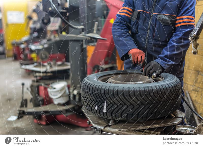 Professioneller Automechaniker beim Reifenwechsel im Autoreparaturdienst. Mechaniker Flugzeugwartung Ersatz Werkstatt Reparatur PKW Arbeiter Dienst fixieren Rad