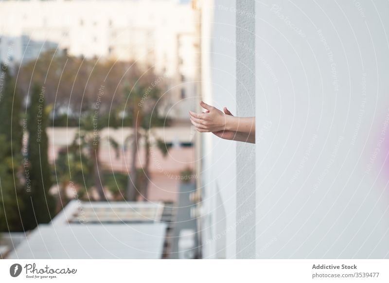 Person, die aus dem Fenster schaut und den Menschen auf der Straße in die Hände klatscht Klatschen Windstille abstützen Balkon Hand Hof Interesse neugierig