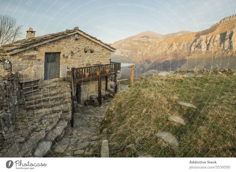 Altes Steinhaus mit kleiner Holzterrasse in bergigem Gebiet in Spanien Haus Landschaft Gelände Architektur Gebäude gealtert abgelegen friedlich Dorf Terrasse