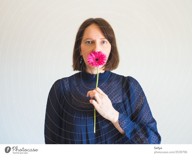 Wunderschönes weibliches Porträt mit rosa Gerbera-Blüte Frau Blume Schönheit Muttertag Mode eine einzigartig Haut Auge Pflege Gesicht jung Hand Beteiligung