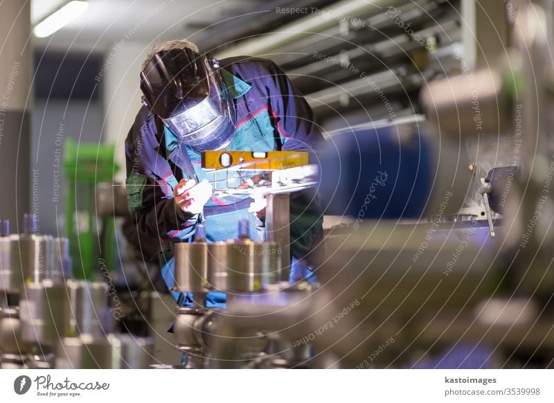 Industriearbeiter beim Schweißen in einer Metallfabrik. Schweißer Arbeiter inox Stahl Kunsthandwerker industriell Handwerk Herstellung Maschinenbau Fabrik