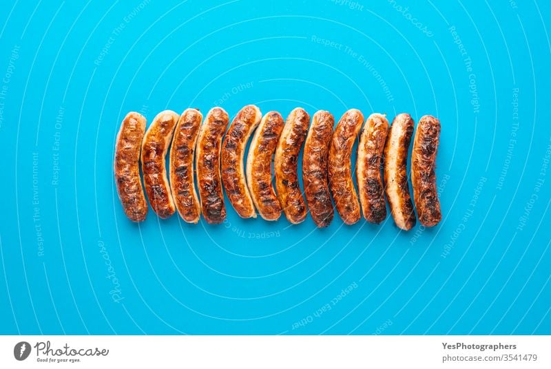 Gegrillte Nürnberger Bratwurst. Deutsche Würstchen Draufsicht obere Ansicht authentisch Barbecue Bayern bayerisch grillen Blauer Hintergrund braun Weihnachten