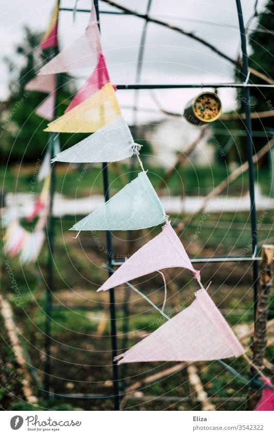 Eine bunte Wimpelkette als Dekoration im Garten bewölkt grau aufhübschen dekorieren Tristesse Dekoration & Verzierung Feste & Feiern Partydekoration Gartenparty